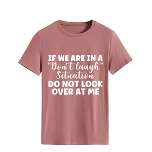 Detail of soft pink cotton t-shirt featuring white slogan print and ribbed crew neckline