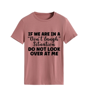 Detail of crew neck t-shirt in dusty pink featuring black slogan print and soft texture