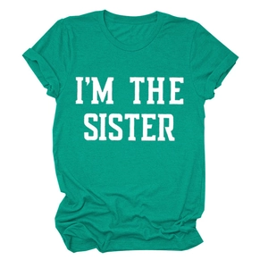 Détail des manches à revers et imprimé lettres blanches sur un t-shirt vert décontracté