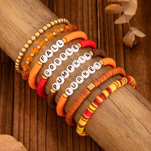 Detail of Thanksgiving layered beaded bracelets with maple leaf and holiday letter beads