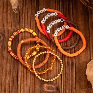 Detailed close-up of Thanksgiving beaded bracelets with maple leaf and fall-themed charms