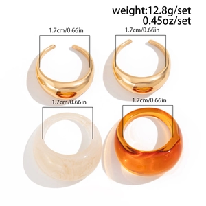 Detailweergave van een vierdelige ringset met goudmetaal en marmeren harsringen