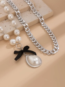 Detail of multi-layer pearl necklace featuring a velvet bow and water-drop pearl pendant