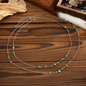 Detail of bohemian long necklace with turquoise beads and silver metal chain link