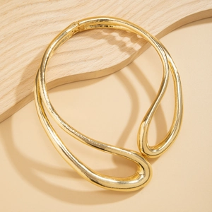 Λεπτομέρεια του χρυσού μεταλλικού choker με ακανόνιστο, αεροδυναμικό, κούφιο σχέδιο