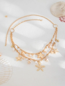 Detail of layered gold ocean body chain with starfish pendants and natural shells