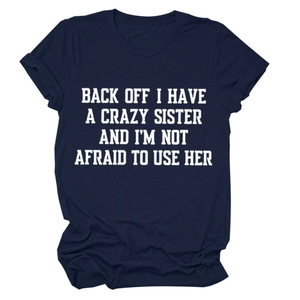 Detail of navy blue crew neck tee featuring white artistic letter print on soft cotton