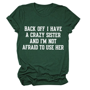 Close-up of dark green cotton T-shirt featuring white bold typographic print on fabric