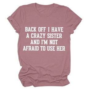 Detail of dusty rose T-shirt showing rolled cuffs and funny white graphic slogan print