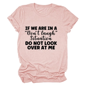 Detail of pink cotton t-shirt featuring bold black typography with humorous slogan print