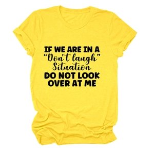 Close-up of yellow cotton t-shirt featuring bold black 'Don't laugh' slogan on the chest