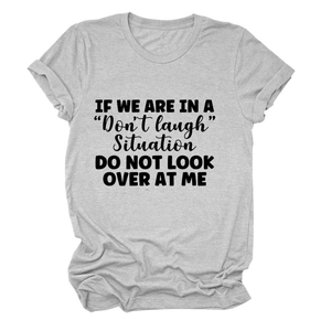 Detail view of heather grey t-shirt featuring bold 'Don't laugh' slogan print