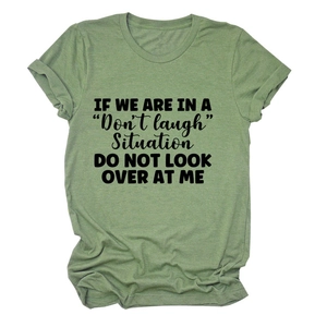 Close-up of green cotton t-shirt featuring black slogan print and folded hem detail
