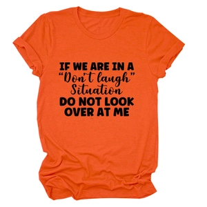 Detail of orange cotton T-shirt featuring funny black quote text print on chest