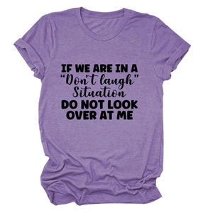 Detailed view of the letter print on a purple crew neck cotton t-shirt flat lay