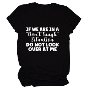 Detail of black cotton T-shirt featuring white 'Don't Laugh' slogan and ribbed crew neck