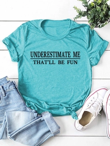 Detail eines blaugrünen T-Shirts mit 'UNDERESTIMATE ME'-Aufdruck und modischem Knotensaum