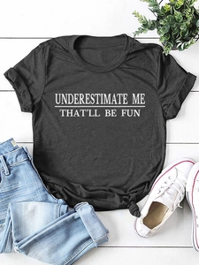 Detailansicht des Underestimate Me Aufdrucks auf einem schwarzen Kurzarm-T-Shirt