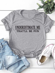 Flach liegendes graues T-Shirt mit Underestimate Me Aufdruck und Knoten am Saum