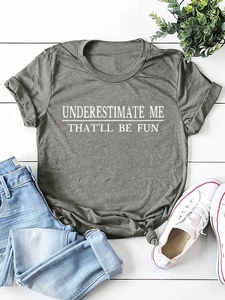 Flachbild eines grauen T-Shirts mit Spruch auf Holzboden mit Accessoires
