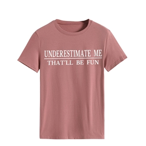 Detail eines rosa Baumwoll-T-Shirts mit weißem UNDERESTIMATE ME THAT'LL BE FUN Textaufdruck
