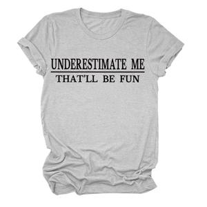 Flach liegendes hellgraues Rundhals-T-Shirt mit dem Aufdruck 'UNDERESTIMATE ME' Spruch