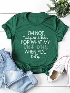 Detail of dark green t-shirt with I'M NOT responsible slogan on white wood background