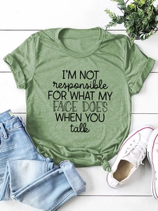 Detail of green T-shirt with I'M NOT responsible slogan print on white wood background