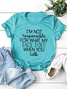 Flat lay of cotton t-shirt with slogan, blue jeans and white canvas shoes on wood