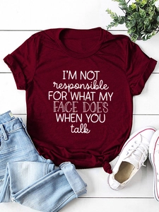 Detail of burgundy T-shirt with white slogan print and stylish front knot detail
