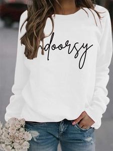 Close-up of white crewneck sweatshirt featuring black indoorsy script print and soft texture