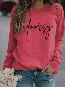 Close-up of red crew neck sweatshirt with Indoorsy script print and soft fabric texture