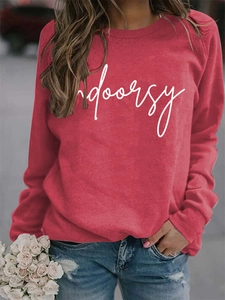 Detail of red crewneck sweatshirt with indoorsy print styled with blue jeans