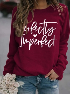 Detail of burgundy sweatshirt with white Perfectly Imperfect print and heart graphic