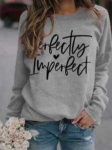 Detail of grey sweatshirt showing Perfectly Imperfect script and heart print fabric texture