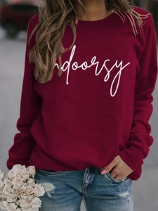 Detail of burgundy sweatshirt featuring a white script indoorsy print on the chest
