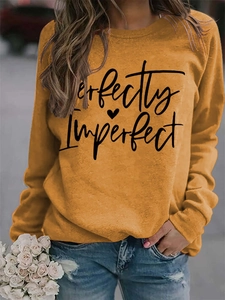 Detail of Perfectly Imperfect text and heart print on ginger yellow sweatshirt fabric