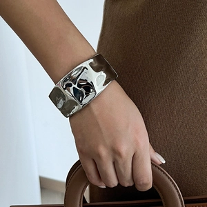 Detailed close-up of wide irregular silver alloy cuff bracelet with liquid metal texture