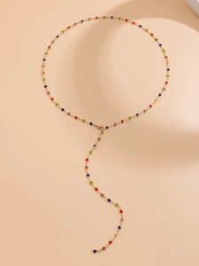 Detail of elegant gold Y-shaped necklace with colorful crystals and long tassels