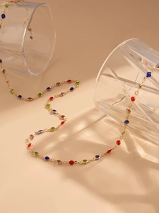 Detail of a luxury gold Y-necklace with multi-color crystals and tassel design