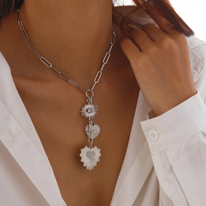 Silver paperclip necklace with zircon sun eye and double heart pendants on a model