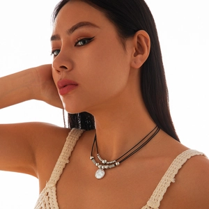 Minimalistische dubbellaagse choker ketting met zilveren kralen en getextureerde hanger