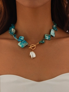 Detail of bohemian shell bead necklace featuring blue turquoise stones and baroque pearl