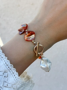 Detail of bohemian necklace with irregular shells and large baroque pearl charm