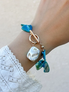Close-up of bohemian beaded bracelet with dark blue stones and baroque pearl detail