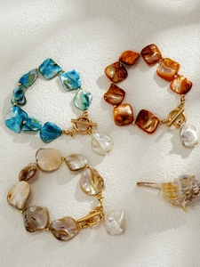 Detail of bohemian shell beads with gold toggle clasp and white baroque pearl pendant