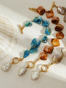 Close-up of bohemian resin beaded bracelets with golden toggle clasp and pearl charms