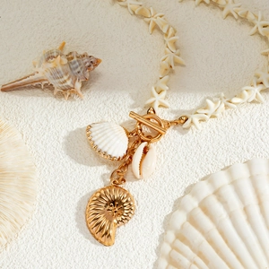 Close-up of ocean-style necklace with star beads, golden OT clasp and seashell pendants