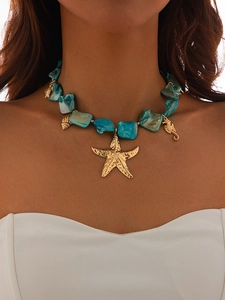 Macro detail of Bohemian turquoise beaded necklace with golden starfish and sea charms