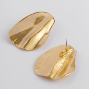 Boucles d'oreilles dorées en forme de feuille avec textures polies et brossées